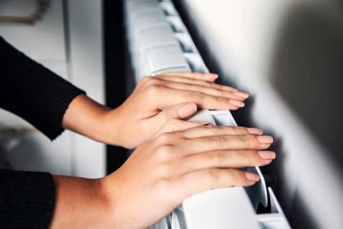 Femme chauffant ses mains sur le radiateur