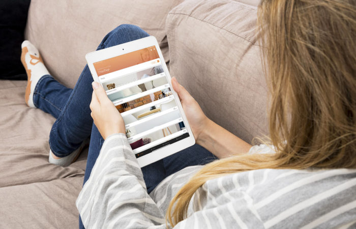 femme sur canape avec tablette et application chauffage