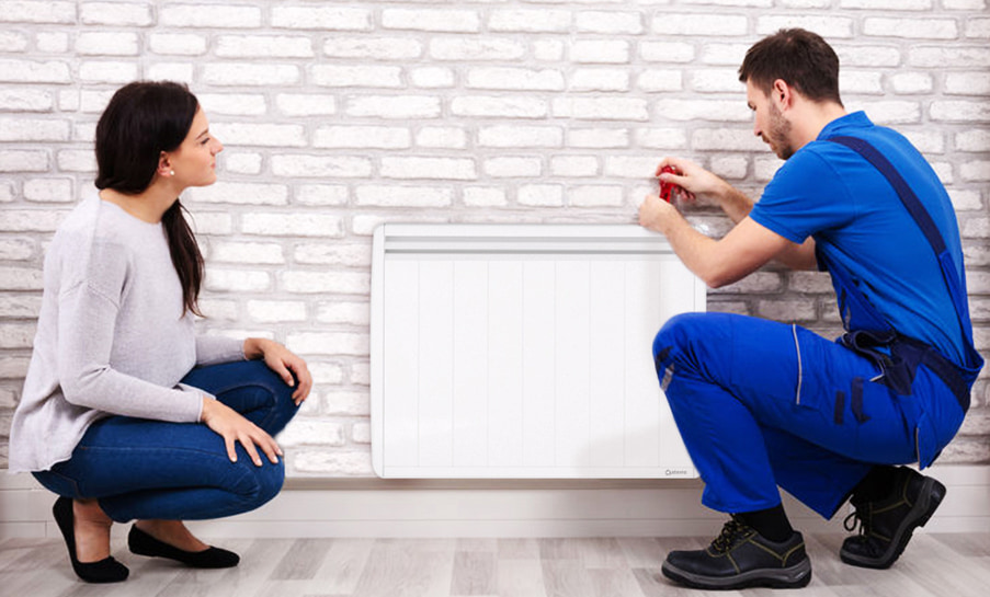 femme avec un technicien qui installe un radiateur a inertie