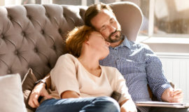 couple confortablement installé sur un canapé, profitant d'un moment de détente procuré par le chauffage à inertie aterno