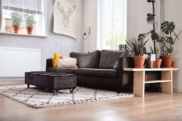 Salon avec un canapé et un radiateur électrique basse consommation Aterno.